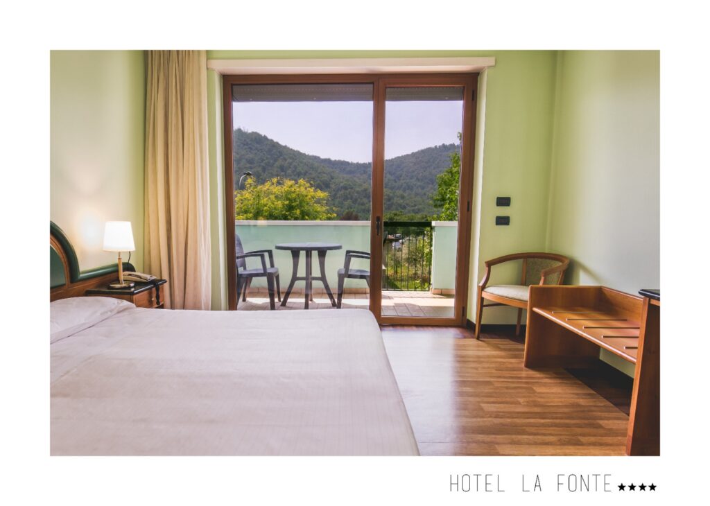 Camera da letto con balcone e vista sulle colline verdi